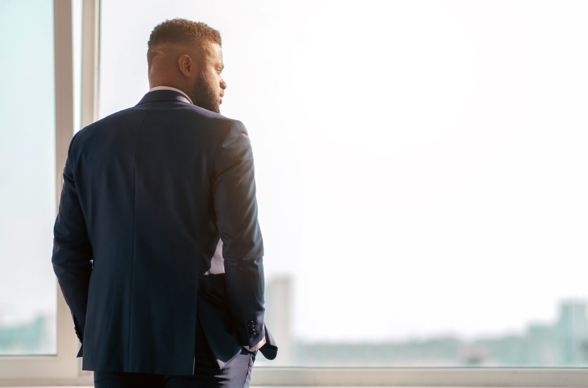 man in business suit contemplates future in office utc